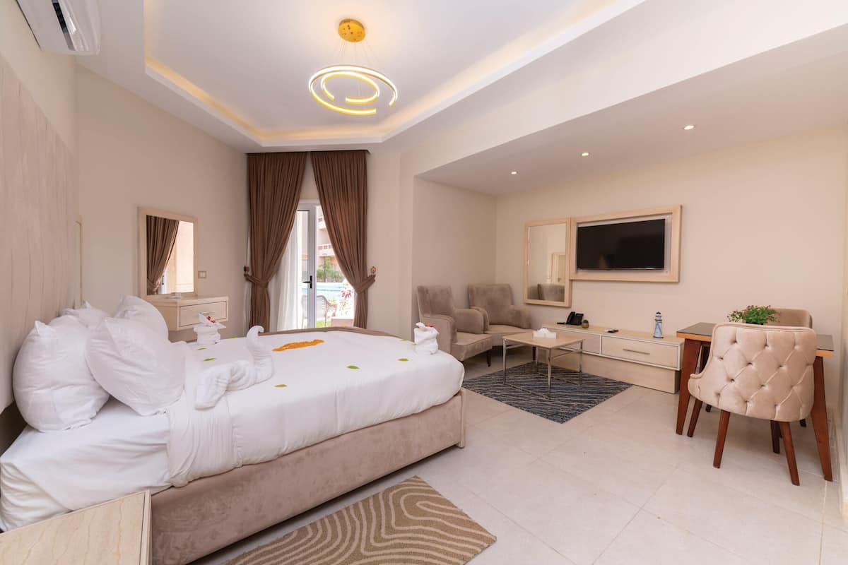 Una habitación de hotel moderna con una cama grande, un escritorio, una silla y un televisor.