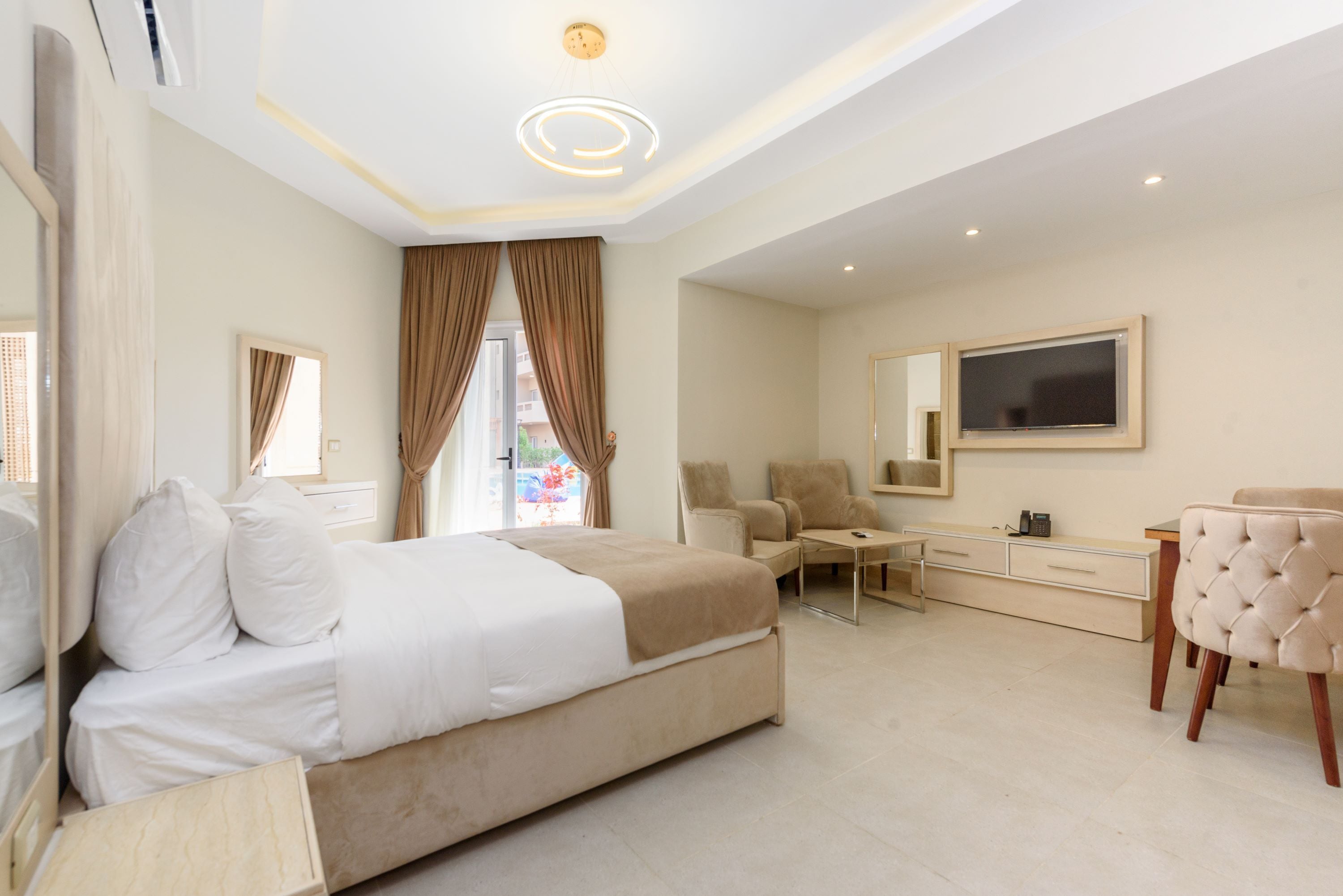 Una habitación de hotel moderna con una cama grande, un escritorio, una silla y un televisor.