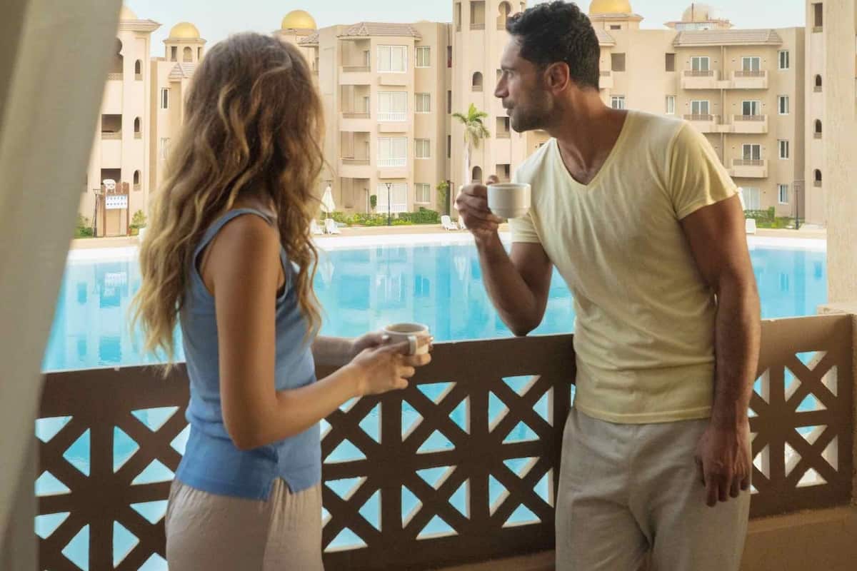 Un balcón con vistas a una piscina y edificios de hotel.