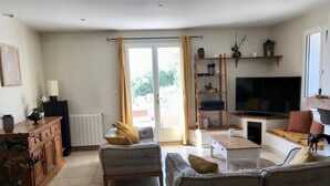 A living room with a sofa set, a coffee table, a TV, and a bookshelf.