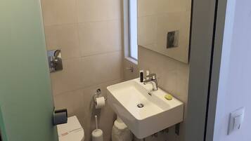 Ein Badezimmer mit Waschbecken, Toilette und Fenster.