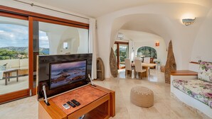 A modern living room with a flat-screen TV, wooden coffee table, and a sofa. - Villa Adele, sea view, pool, 700 meters from the beach (MONTE PETROSU)