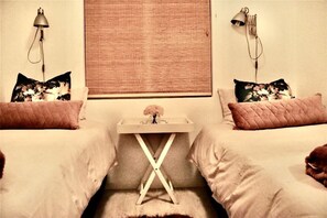 Two single beds, each with a quilted duvet and floral pillow, are positioned in this inviting bedroom.