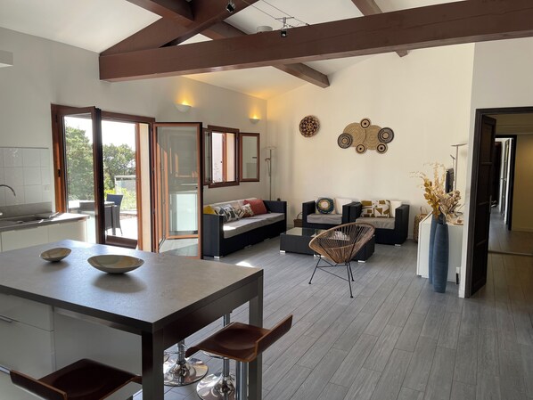 Un espacio habitable moderno y abierto con cocina, mesa de comedor y zona de estar.