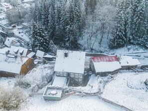 Ett snötäckt bostadsområde med hus och en stor byggnad med ett rött tak.