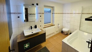 Une salle de bain moderne avec un lavabo, des toilettes et une baignoire.