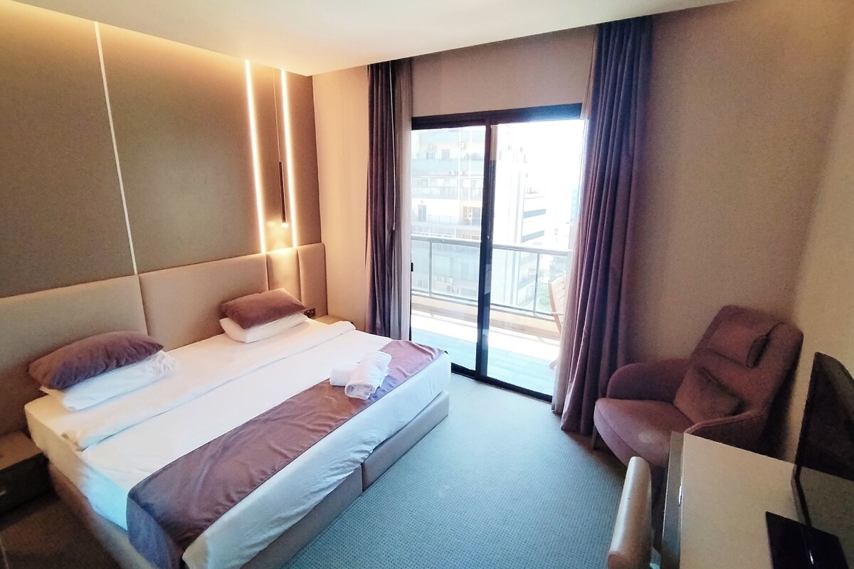 Une chambre d’hôtel avec un grand lit, un bureau et une chaise.