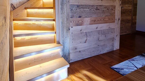 A wooden staircase with built-in lighting leading to a landing area. - Casa Margherita (Challand-Saint-Anselme)