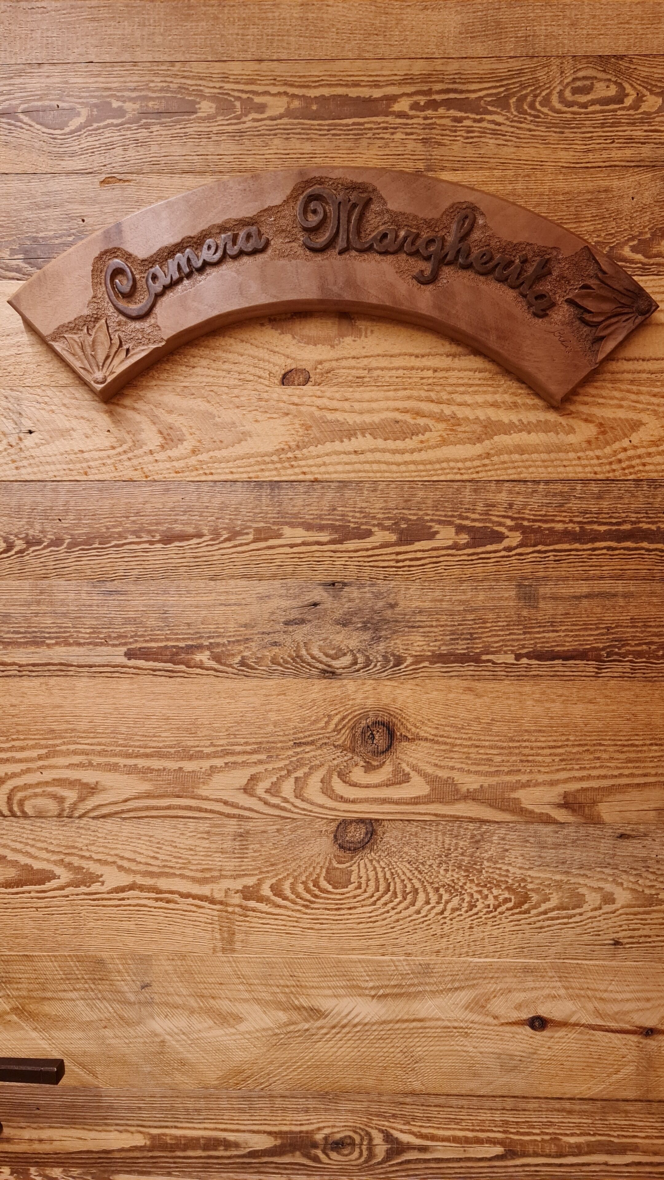 A wooden plaque with the inscription "Camela Manor."