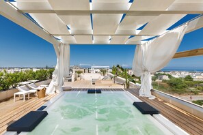 Piscina infinita en la azotea con vistas despejadas a la ciudad y al mar.