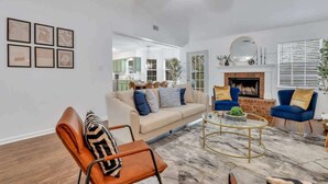 A modern living room with a sofa, armchairs, a coffee table, and artwork on the wall. - Restful Escape near Savannah (Richmond Hill)