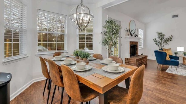 A spacious dining area with a wooden table set for six, surrounded by six chairs. - Restful Escape near Savannah (Richmond Hill)