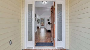 A hallway leading to a room with a door, a small rug at the entrance, and a ceiling light fixture. - Restful Escape near Savannah (Richmond Hill)