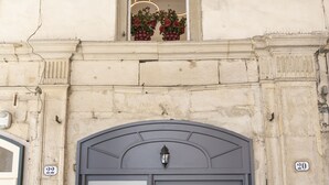 A building facade with a large, dark-colored entrance door labeled "Le Stanze del Savonarola." - Le stanze del Savonarola  (Ferrara)