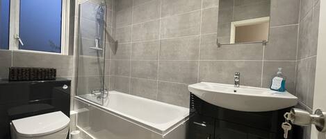 Un baño moderno con bañera, inodoro y lavabo.