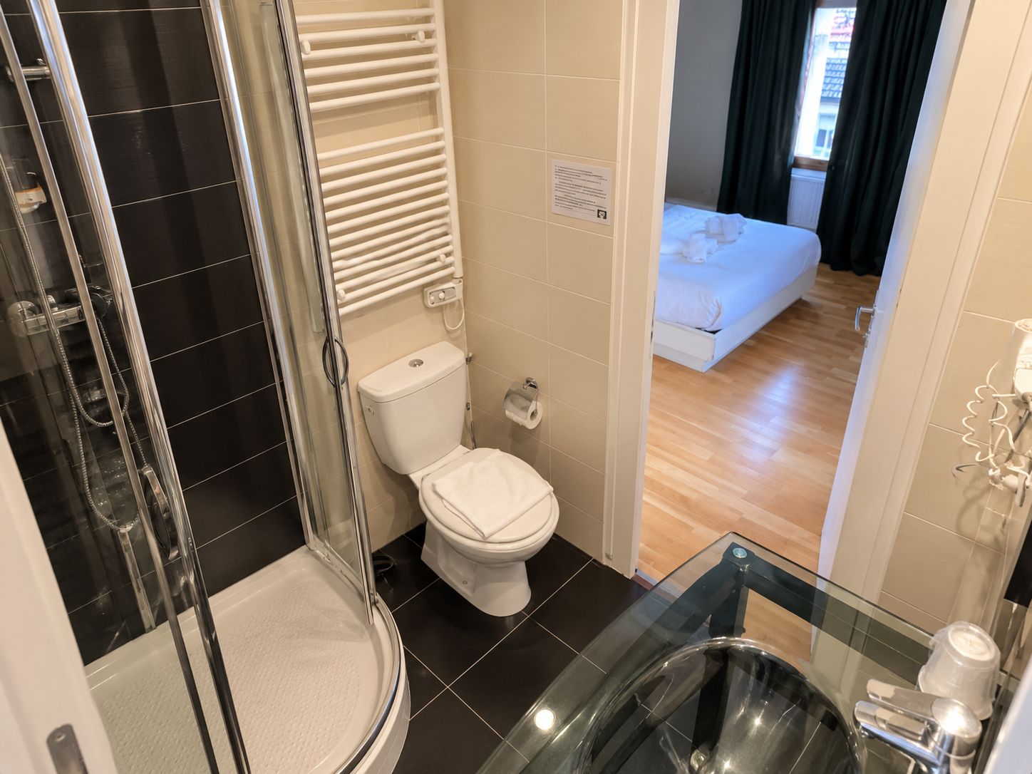 Une salle de bain moderne avec une douche à parois de verre, des toilettes et un lavabo en verre.