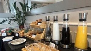 A buffet setup with various food items, beverages, and glassware. - Le Divona (Divonne-les-Bains)