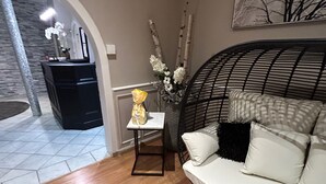 A modern living room with a sofa, a small table, and a decorative vase. - Le Divona (Divonne-les-Bains)