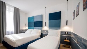 Une chambre d’hôtel avec deux lits, un mur décoratif en marbre et des œuvres d’art accrochées au mur.