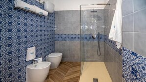 Une salle de bain avec douche, toilettes et lavabo.