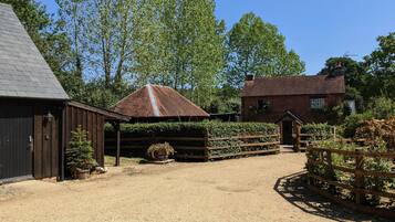 A rural property with a stable, a wooden fence, and a gravel driveway.