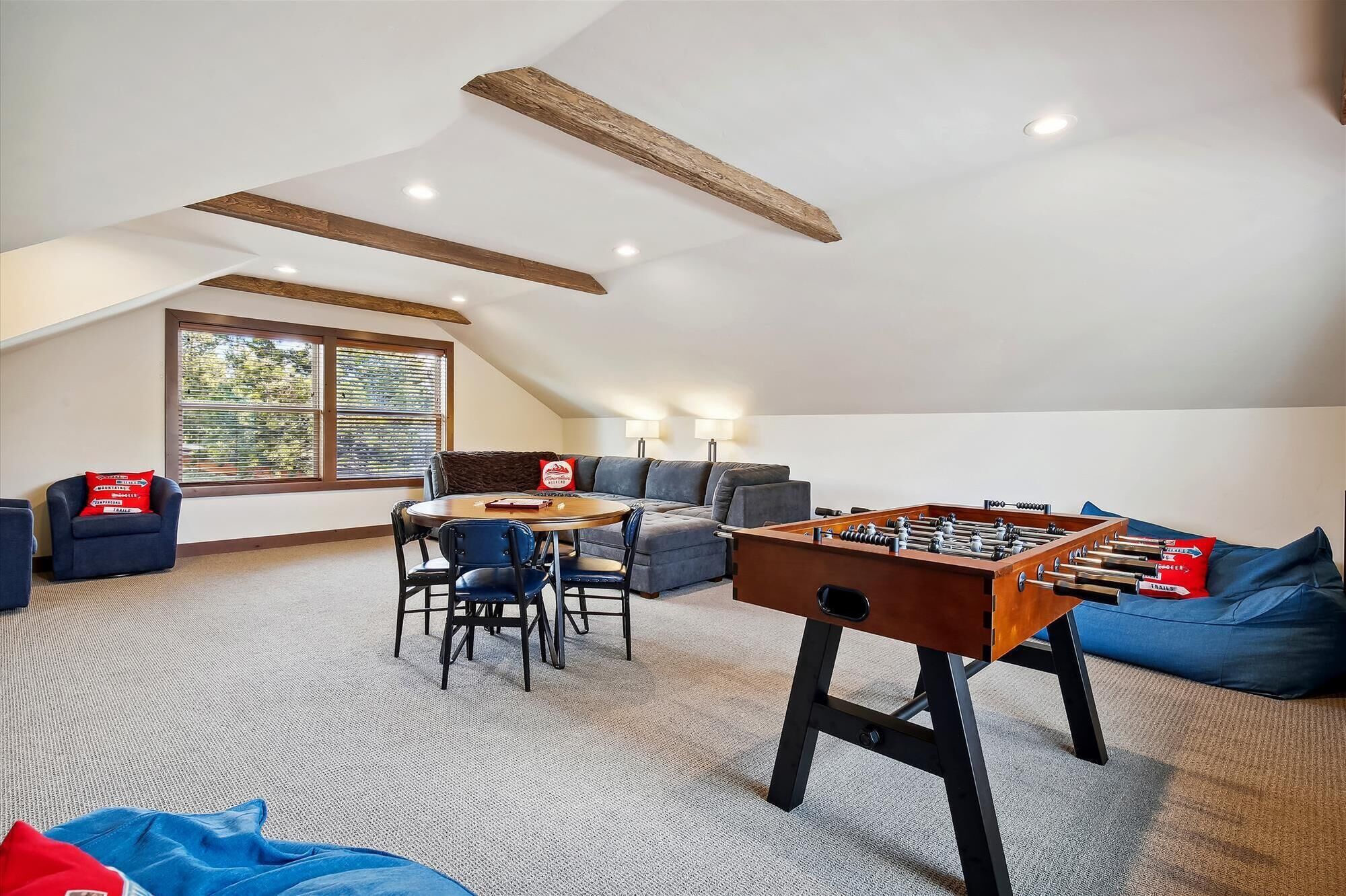 Une pièce de style loft avec une table de baby-foot, un canapé et un coin repas.