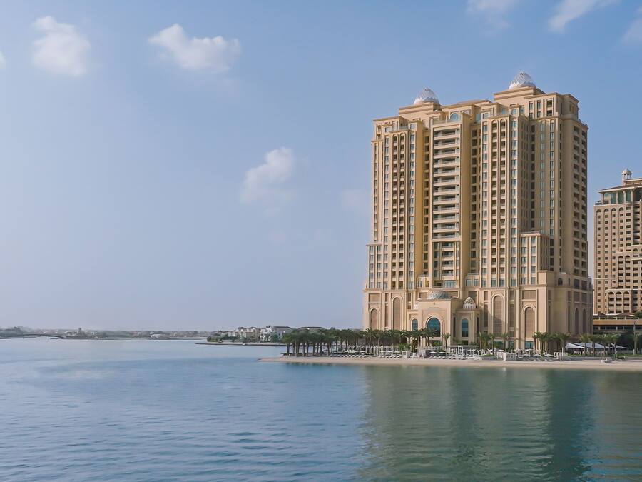 A high-rise hotel with multiple balconies and a waterfront view.
