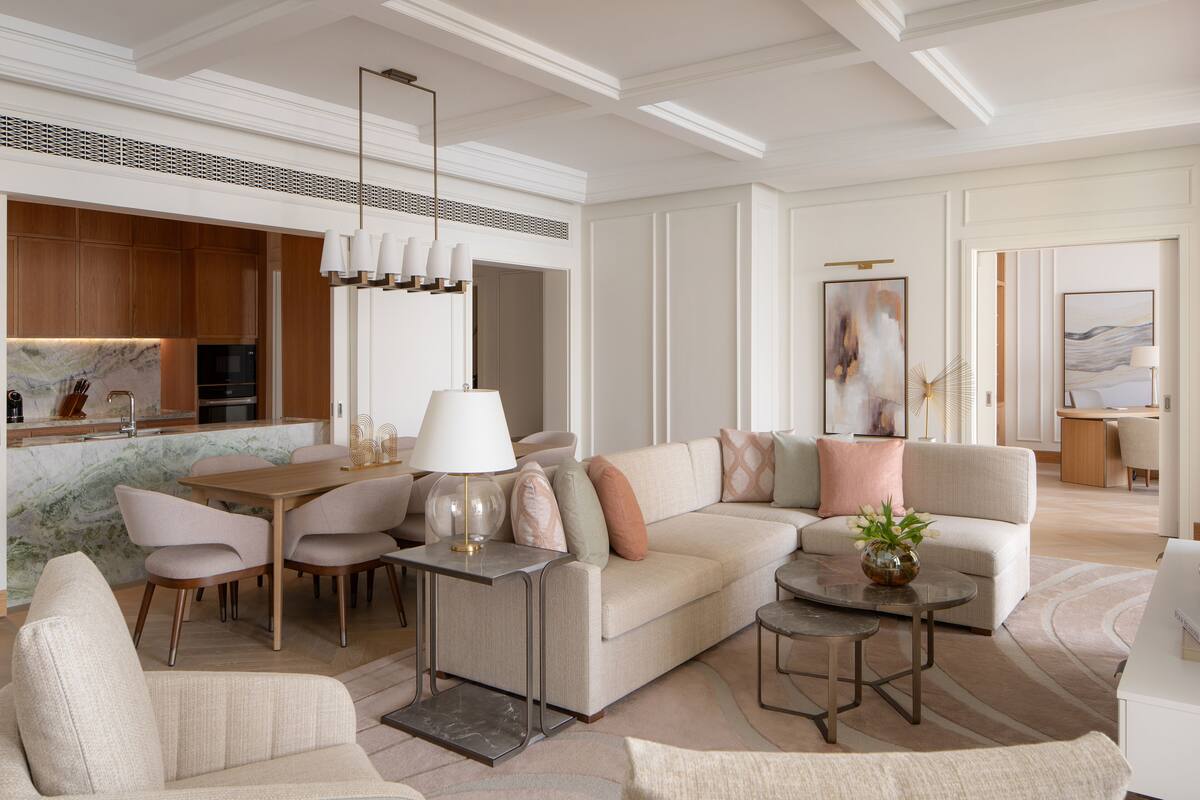 Un salon moderne comprenant un canapé, des fauteuils, une table basse et un coin repas.