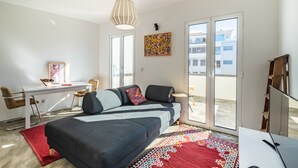 A modern bedroom with a bed, desk, and a view through a sliding door. - Casa Luar - By Wehost (Funchal)