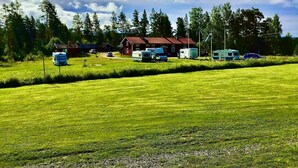 A campground with RVs and trailers, surrounded by trees and a clear sky. - Ramsjö Camping (Ramsjö)