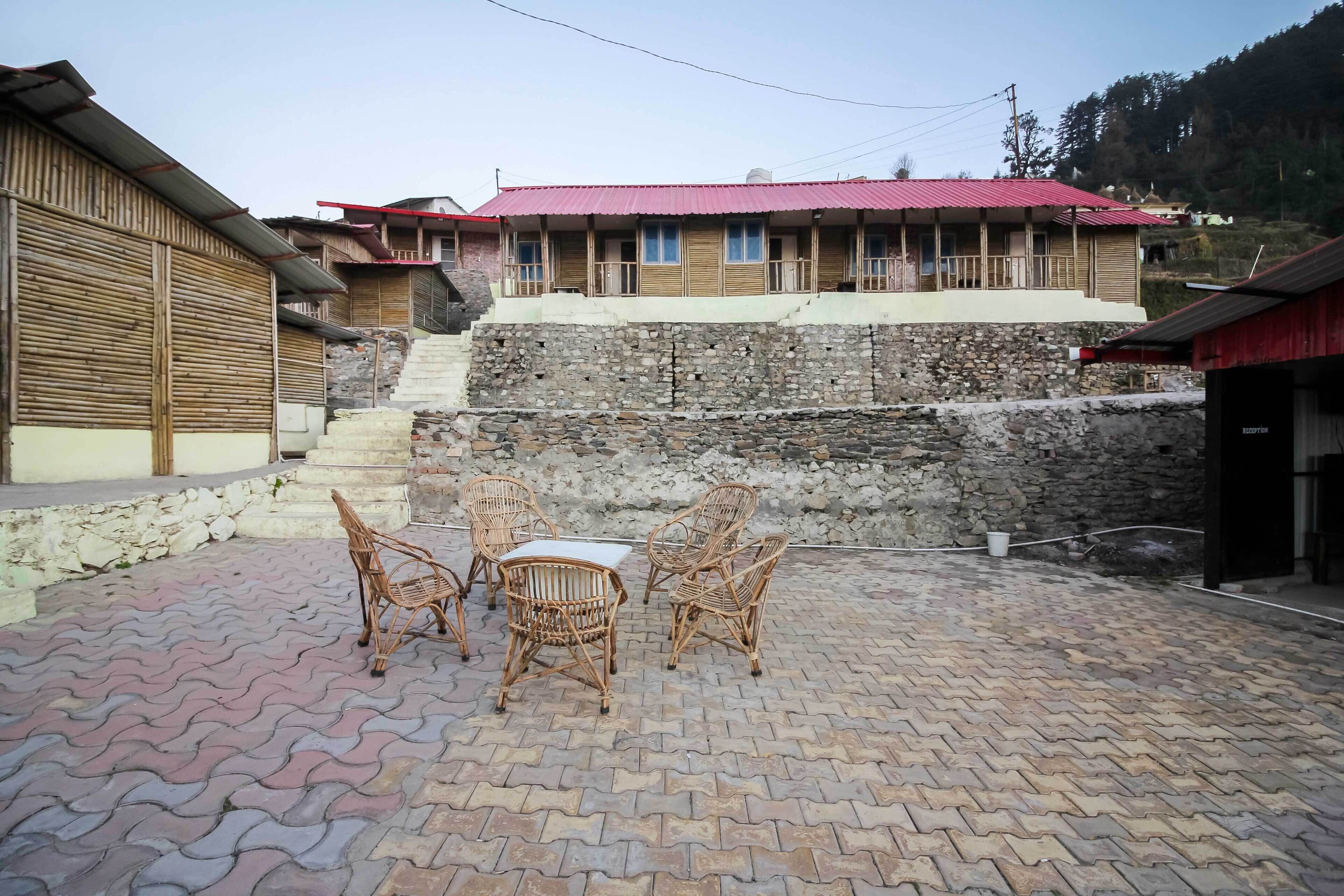 A courtyard with wicker furniture and a stone wall.