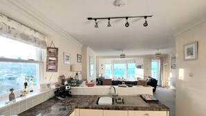 Una cocina amplia con una isla grande, un comedor con vistas y una sala de estar con sofá y mesa de centro.