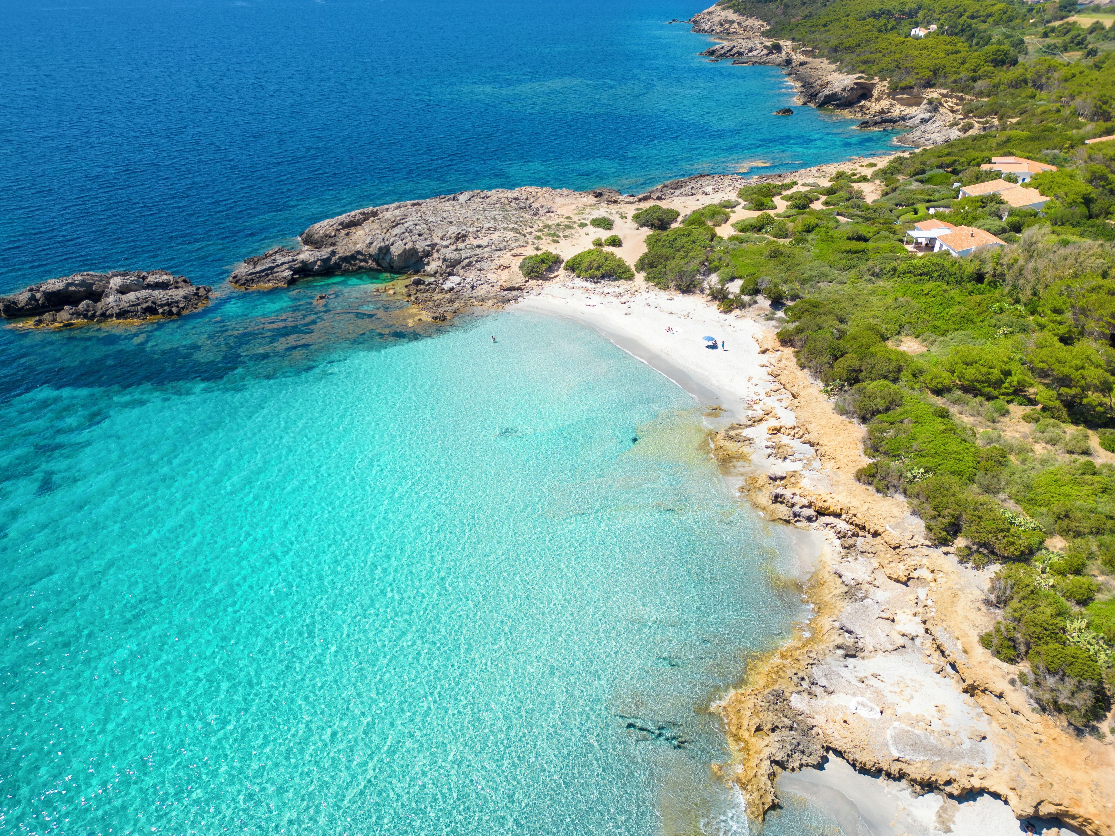 Propiedad costera con playa, costa rocosa y vegetación.