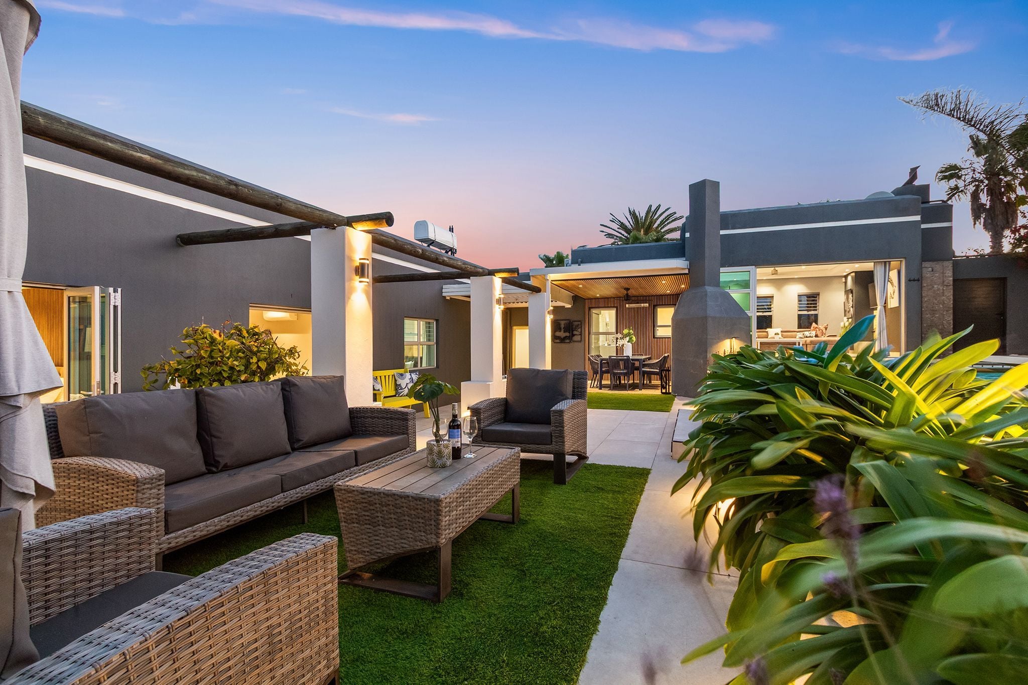 A modern outdoor living area with a sofa, chairs, and a coffee table.