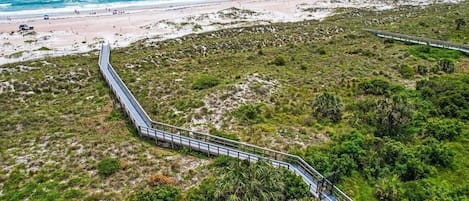 A coastal area with a paved walkway leading to the beach.