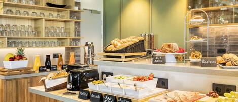 Un bufé de desayuno con diversas opciones de comida y una máquina de café.