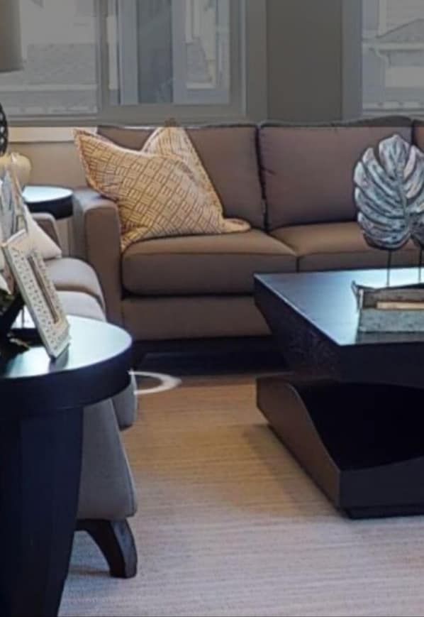 A modern living room with a brown sofa, a round side table, and a coffee table.
