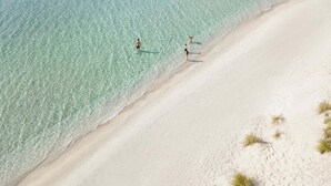 A beach with clear turquoise water and white sand.