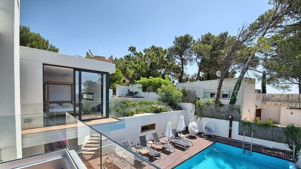 A modern poolside area with a glass balustrade, lounge chairs, and a clear blue pool. - Villa 'Amapola' with Mountain View, Wi-Fi and Air Conditioning (Begur)