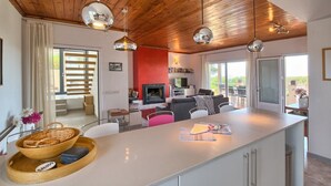 A modern kitchen with a central island, wooden ceiling, and pendant lighting. - Villa 'Amapola' with Mountain View, Wi-Fi and Air Conditioning (Begur)