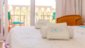 A hotel room with a bed, a wooden headboard, and a view of a balcony with a railing and chairs. - Holiday Home 'Villa Lidia' with Sea View, Private Pool and Wi-Fi (Serpentona)