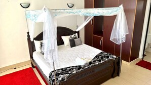 A bed with a canopy, a wardrobe, and a red carpet. - Impeccable 3-bed Apartment in Mombasa (Mombasa)