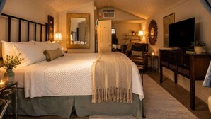 Ein Schlafzimmer mit einem großen Bett, einem Fernseher, einem Spiegel und einem Deckenventilator.