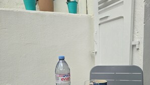 Ett bord med croissanter, apelsiner, en flaska Evian-vatten och en kopp på ett bordsduk.