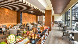 A buffet area with various food options, seating arrangements, and a view of the water outside. - FOX Harris Hotel & Conventions Banjarnegara (Banjarnegara)