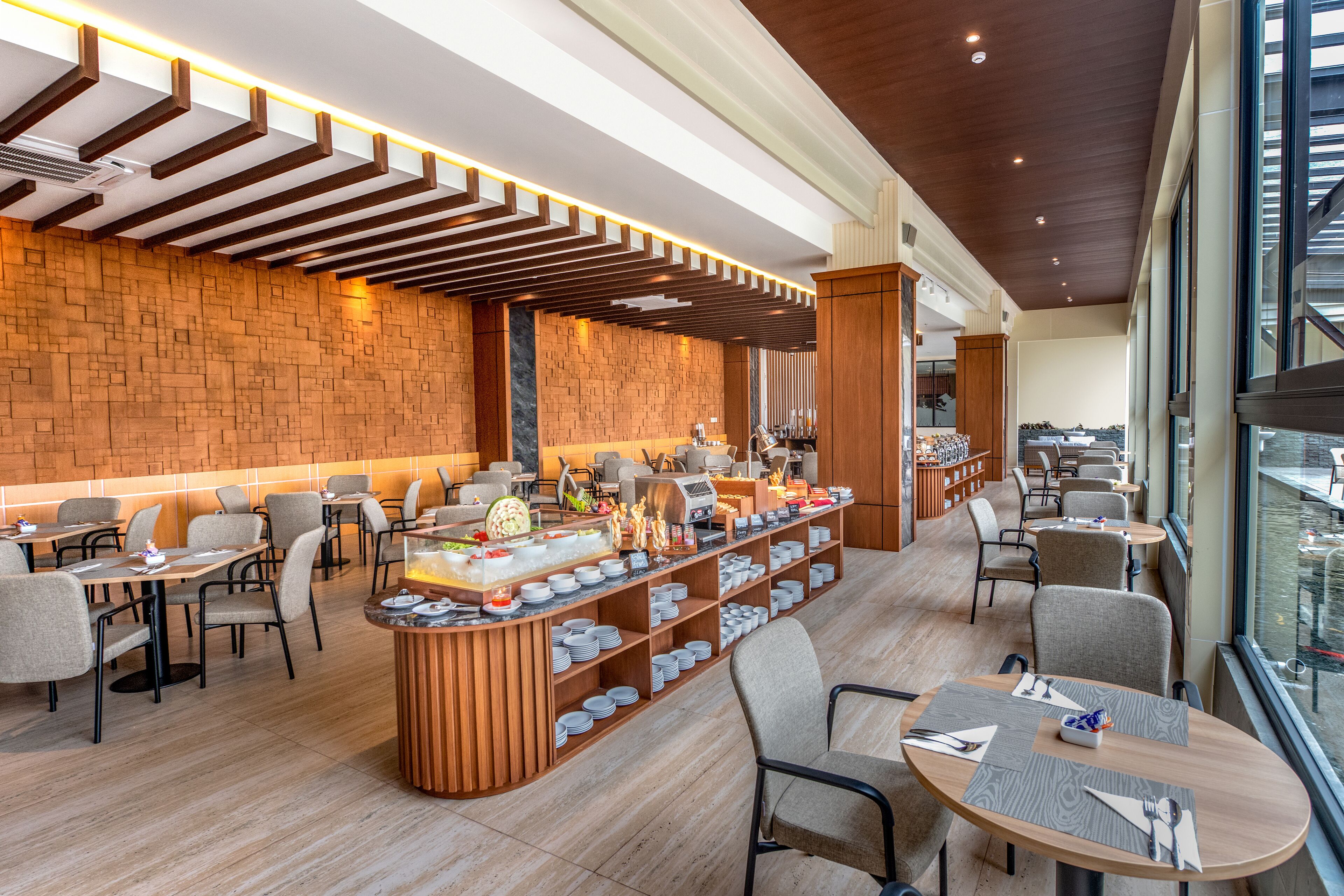 Um restaurante moderno com parede de tijolos, teto de madeira e balcão de buffet.