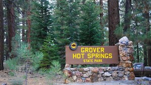 Señal de Grover Hot Springs State Park rodeado de árboles.