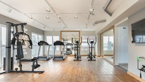 A spacious gym with treadmills, ellipticals, and weight machines. - Studio Moderno Bela Vista | Wifi 250 mb (São Paulo)