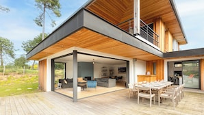 A modern house with a wooden deck, a dining area, and a living room with a sofa and chairs. - SPRING . KEYWEEK - Contemporary villa with pool in the hea (Anglet)