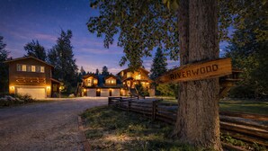 Eine zweistöckige Holzhütte mit einem Schotterweg und einem Holzschild, das den Namen 'Riverwood' zeigt.